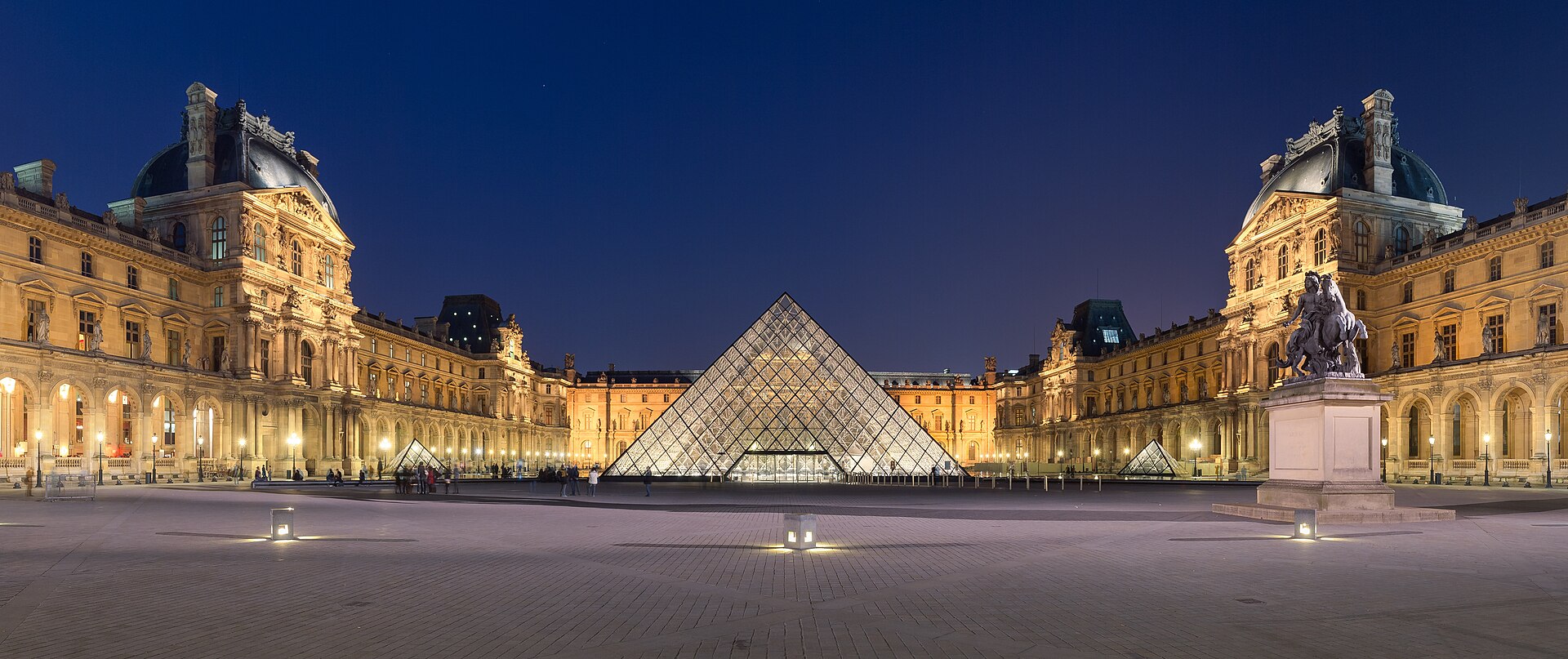 Pyramide du Louvre la nuit avec la cour Napoléon illuminée